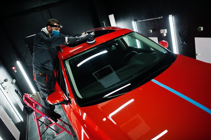 Professional detailer performing paint correction at Bright Cars