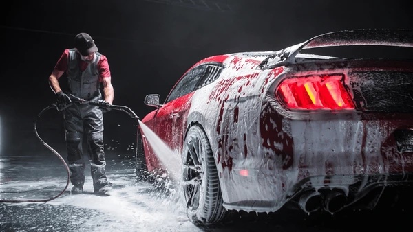 Detailer washing a vehicle at Bright Cars